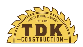 A yellow, semi-circular saw blade logo for TDK Construction, featuring the text 